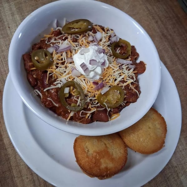 Brisket BBQ chili with shredded cheese, red onions, sour cream, and jalapeños, served with cornbread.